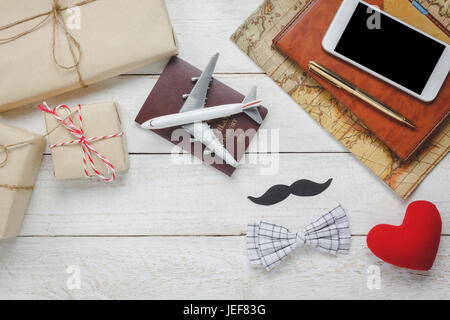 Top view Happy Father day with travel.Airplane and passport on rustic wooden background.accessories with ,map,mustache,vintage bow tie,pen,present,red Stock Photo