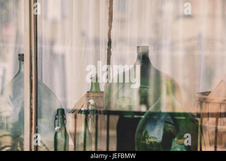 Old empty wine bottles behind the glass with street reflection Stock Photo