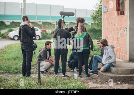 Behind the scene. Film crew team filming movie scene on outdoor location. Group cinema set Stock Photo