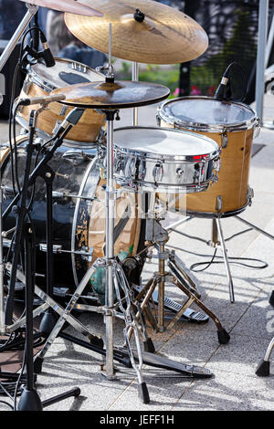 drum set with microphones standing on outdoor stage Stock Photo