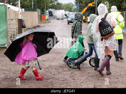A young festivalgoer shelters under an umbrella at Glastonbury Festival, at Worthy Farm in Somerset. PRESS ASSOCIATION Photo. Picture date: Saturday June 24, 2017. See PA story SHOWBIZ Glastonbury. Photo credit should read: Yui Mok/PA WireA young festival goer carrying a giant umbrella in the rain at the Glastonbury Festival at Worthy Farm in Pilton, Somerset. PRESS ASSOCIATION Photo. Picture date: Saturday June 24, 2017. See PA story SHOWBIZ Glastonbury. Photo credit should read: Yui Mok/PA Wire Stock Photo