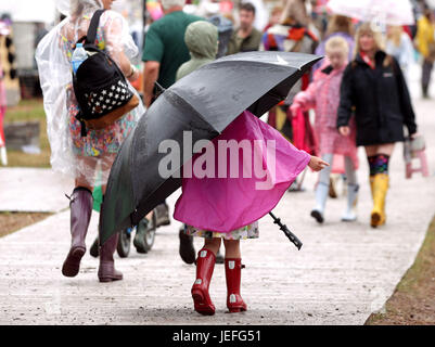 A young festivalgoer shelters under an umbrella at Glastonbury Festival, at Worthy Farm in Somerset. PRESS ASSOCIATION Photo. Picture date: Saturday June 24, 2017. See PA story SHOWBIZ Glastonbury. Photo credit should read: Yui Mok/PA WireA young festival goer carrying a giant umbrella in the rain at the Glastonbury Festival at Worthy Farm in Pilton, Somerset. PRESS ASSOCIATION Photo. Picture date: Saturday June 24, 2017. See PA story SHOWBIZ Glastonbury. Photo credit should read: Yui Mok/PA Wire Stock Photo