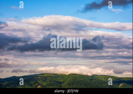 gorgeous colorful cloudscape over the mountain ridge at sunrise Stock Photo