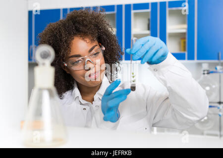 Female Laboratory Scientist Examining Plant Sample In Test Tube, Work In Genetics Lab Stock Photo