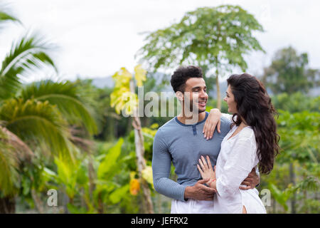 Happy Latin Man Embracing Woman, Young Couple Over Green Tropical Rain Forest Landscape Stock Photo