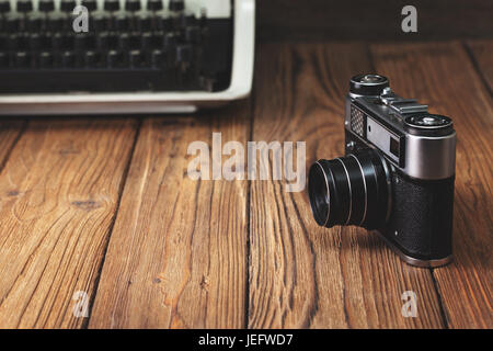 Old camera and typewriter on old wooden background. copy  space.  concept Stock Photo