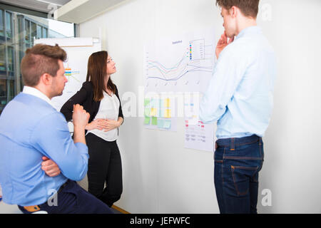 Business Professionals Discussing Over Line Graph In Office Stock Photo
