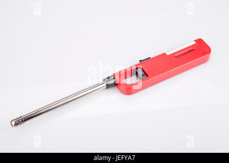 Red gas lighter gun on a white surface. Gas-stove lighter isolated on white background. Stock Photo