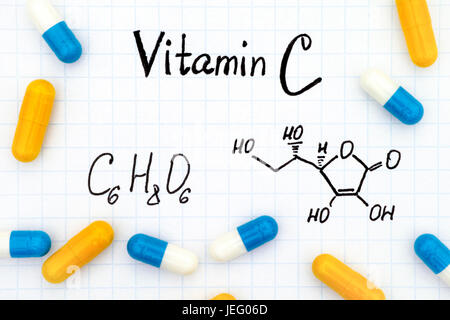Chemical formula of Vitamin C and pills. Stock Photo