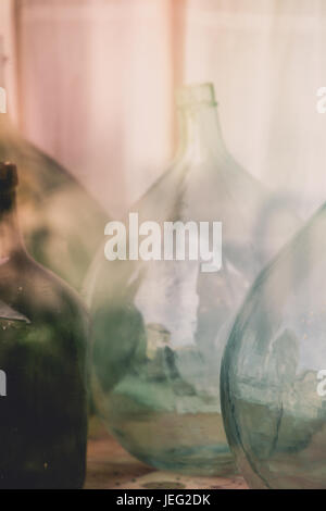 Old empty wine bottles behind the glass with street reflection Stock Photo