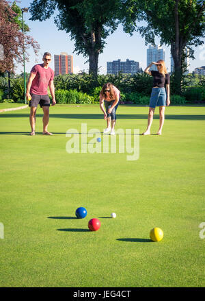 Friends play bocce ball on a manicured bowling green at the Royal Lawn Bowling Club in Edmonton, Alberta, Canada. Stock Photo
