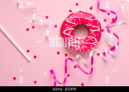 Donuts with icing on pastel pink background with copyspace. Sweet donuts. Stock Photo