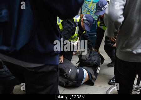 London, UK. 24th June, 2017. Police officers restrain an anti-fascist after a brief clash with members of the English Defence League who had approached the anti-fascist counter-protest on the edge of Trafalgar Square. Credit: Mark Kerrison/Alamy Live News Stock Photo