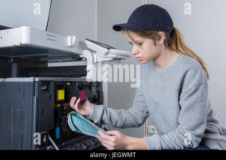 young woman fixing cartridge in photocopy machine at office Stock Photo