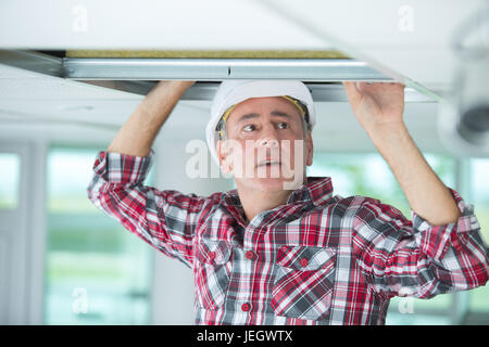 man doing an installation of air conditioner and heating duct Stock Photo