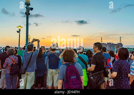 TAIPEI, TAIWAN - MAY 29: Tourists taking photos of the sunset from a pier in the Fisherman's Wharf area of Tamsui on May 29, 2017 in Taipei Stock Photo