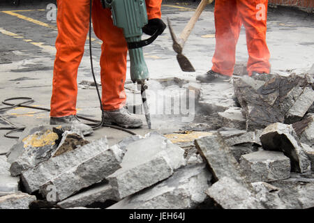 workers at construction site demolishing asphalt Stock Photo