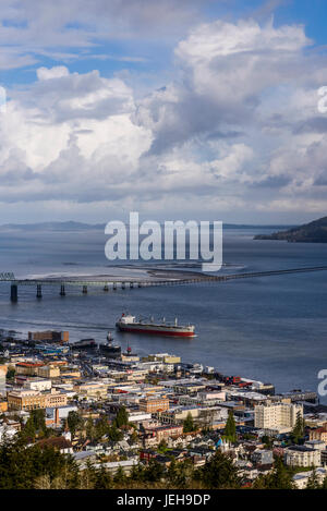 A ship passes the Astoria waterfront on a cloudy morning; Astoria, Oregon, United States of America