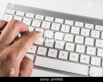 Mac typing a text on a white metal modern keyboard Stock Photo