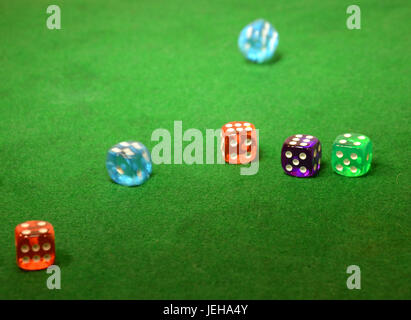 Dice in different colors on a green table. Stock Photo