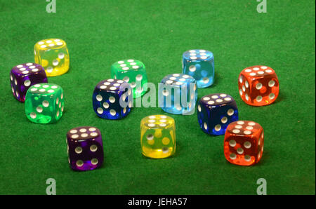Dice in different colors on a green table. Stock Photo