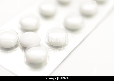 Contraceptive tablets in packages and without on a light background. Stock Photo