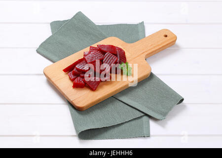 sliced and pickled beetroot on wooden cutting board Stock Photo