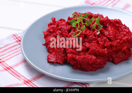 plate of fresh beetroot puree on checkered dishtowel - close up Stock Photo