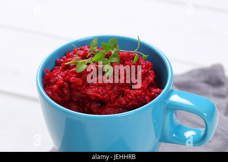 cup of fresh beetroot puree on grey place mat - close up Stock Photo