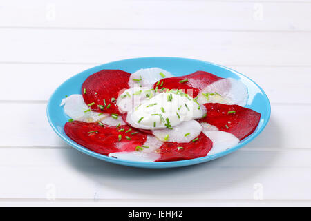 plate of thin beetroot and white radish slices on white wooden background Stock Photo