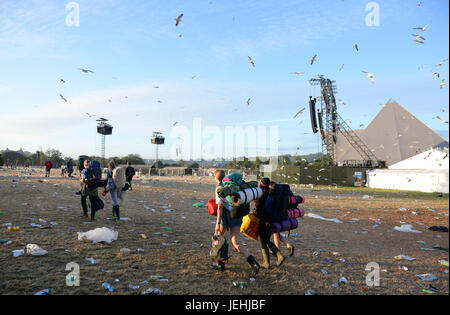 Festival goers leave following the Glastonbury Festival at Worthy Farm in Pilton, Somerset. Stock Photo