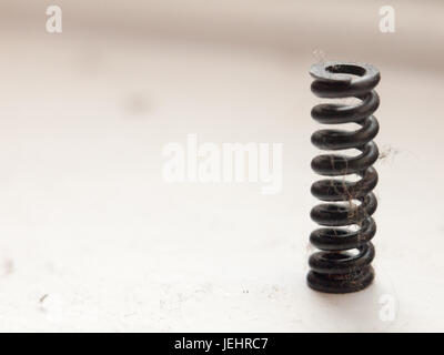 a small black coil spring on white Stock Photo