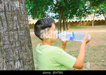 Green eyes boy  drinking water the park Stock Photo