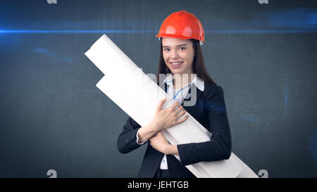 Building, developing, consrtuction and architecture concept -businesswoman in orange helmet with blueprint. Stock Photo