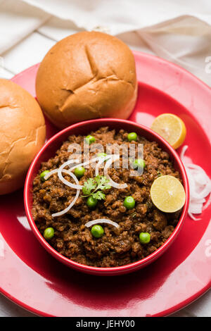 Indian Masala Kheema Pav or khima or Dry Spicy Minced Meat usually served with indian flat bread called kulcha/roti/chapati, garnished with green peas Stock Photo