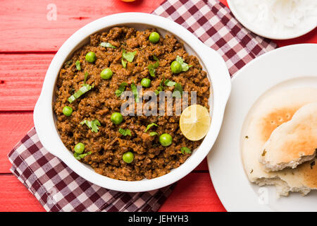 Indian Masala Kheema Pav or khima or Dry Spicy Minced Meat usually served with indian flat bread called kulcha/roti/chapati, garnished with green peas Stock Photo