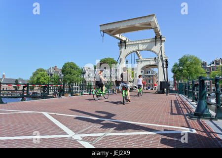 AMSTERDAM-AUG. 19, 2012. Cyclists on famous 'Meager Bridge' Amsterdam. Bicycles outnumber people in Amsterdam: 760,000 citizens and a million bikes. Stock Photo