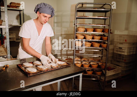 male cook shaping dough for baking bread Stock Photo