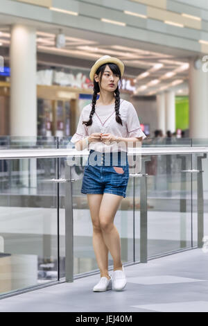 BEIJING-AUGUST 4, 2106. Fashionable young girl in shopping mall. Chinese youngsters sees fashion as a way to reflect aspirations and identity. Stock Photo