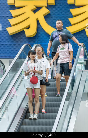 BEIJING-AUG. 4, 2106. People on escalator in shopping mall. China’s economy boosted by middle class wealth undergoes significant shift in consumption. Stock Photo