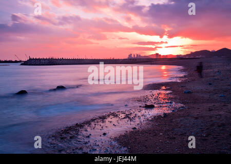 Xinghai Beach at a red colored sunset reflected in the sea, Dalian, China Stock Photo