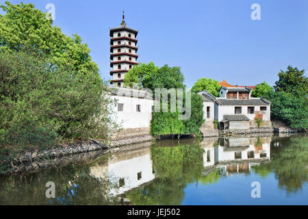 Traditional white Chinese house and pagoda reflected in a tranquil canal, Hengdian World Studios, China Stock Photo