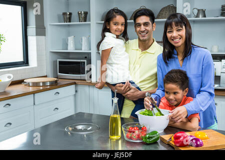 Happy family preparing salad in the kitchen Stock Photo