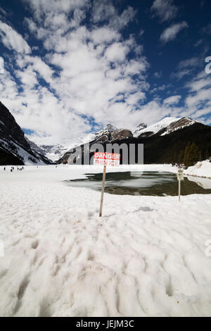 Sign warning of the danger posed by thin ice at Lake Louise in Alberta, Canada. Stock Photo