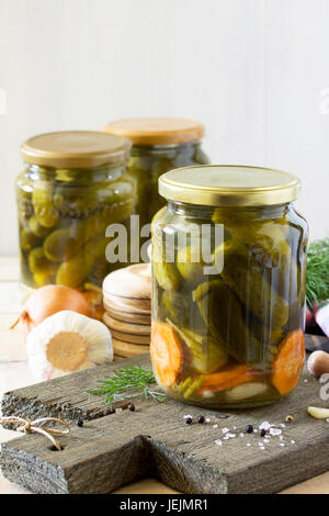 Marinated cucumbers gherkins. Marinated pickles with garlic on the kitchen table. Stock Photo