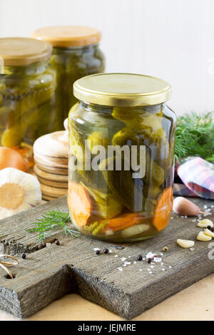Marinated cucumbers gherkins. Marinated pickles with garlic on the kitchen table. Stock Photo