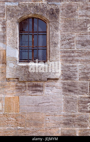 Barred window in stone wall Stock Photo
