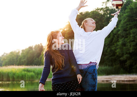 Young couple playing ball at water Stock Photo