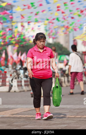 BEIJING-JULY 24, 2015. Overweight middle aged woman in shopping area. China’s obesity rate has skyrocketed over last decades. Stock Photo