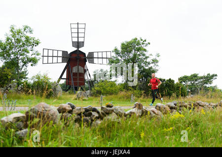 Young man running, windmill on background Stock Photo